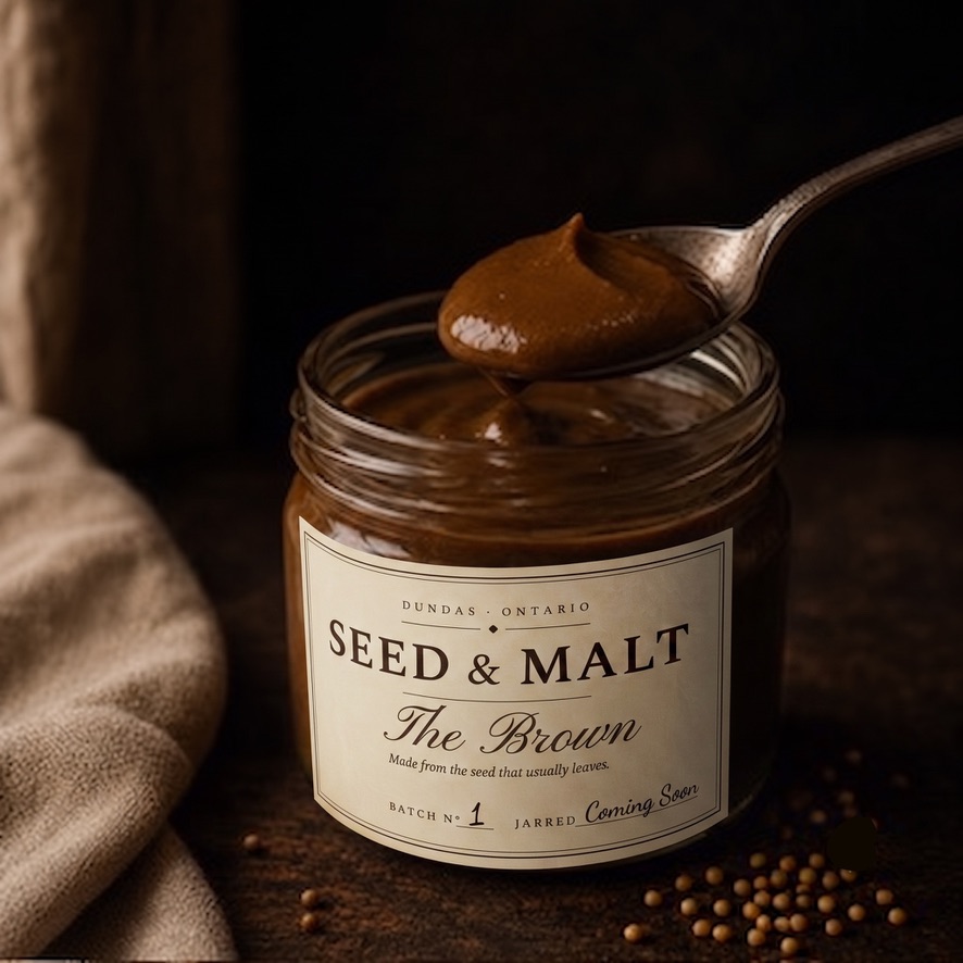 The Brown — dark, smooth brown mustard, a spoon lifting from the jar
